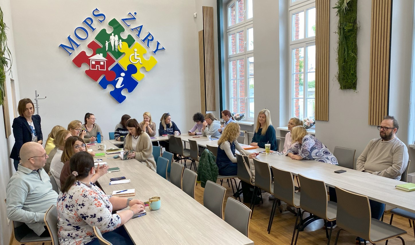 sala konferencyjna MOPS w Żarach z pracownikami MOPS siedzącymi podczas spotkania